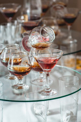 different alcohol drinks on a glass stand. wine, champagne, cognac, vodka, martini