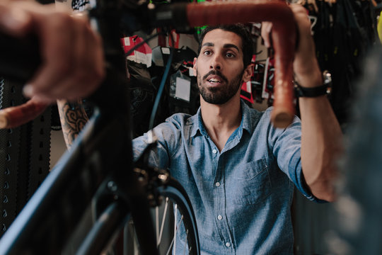 Worker inspecting a bicycle in workshop