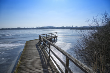 Wooden jetty at the frozen Bederkesa Lake