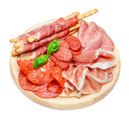 Cold smoked meat plate with pork chops, prosciutto, salami and bread sticks