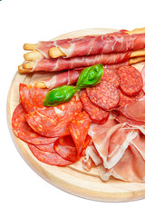 Cold smoked meat plate with pork chops, prosciutto, salami and bread sticks