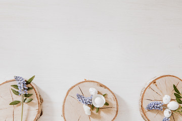 Wooden blocks with grape hyacinths, little eggs and green leaves on the bottom of white wooden table