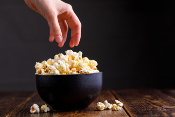 The hand that stretches behind the mouth-watering popcorn.