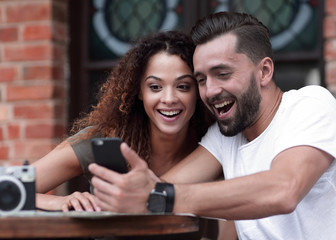 Portrait of a young  couple sitting down at a cafe terrace