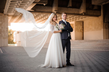 Portrait of a bridegroom standing with a blonde bride near the wedding palace