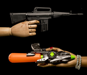 Rifle versus dummy weapon with phallic shape. Concept limitation of weapon. Isolated on black background. With copy space text. Studio Shot.