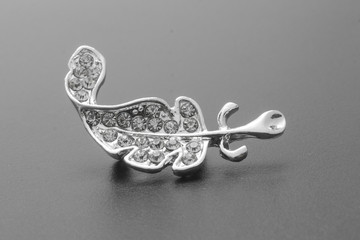 silver brooch feather with diamonds isolated on black