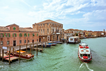 Fototapeta na wymiar Daylight view to Venetian Lagoon canal with parked boats
