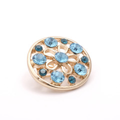 gold round brooch with blue diamonds isolated on white