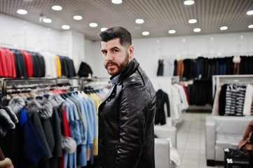 Stylish turkish man at the store of fur coats and leather jackets. Successful arabian beard man.