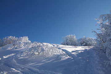 Fototapeta na wymiar winter landscape with snow and blue sky and path to the top of the mountain