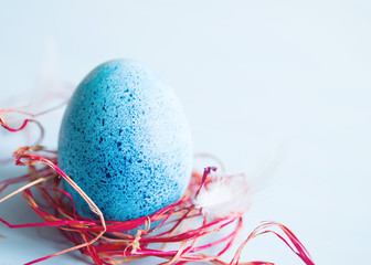 One blue Easter egg on blue background, soft focus