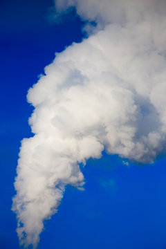 smoke from a pipe in the factory against a blue sky