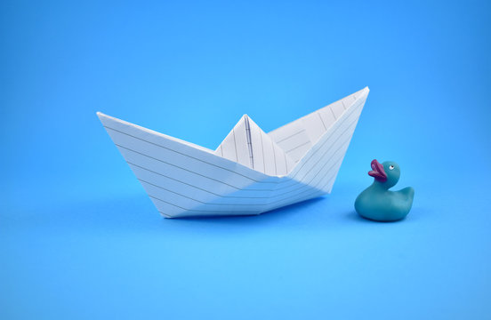 Paper boat stock images. Paper boat with duck. Paper boat on a white background. Blue background with boat