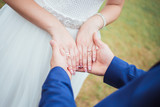 The groom holds the hands of the bride in his hands and the bride has an engagement ring on her finger. Closeup.