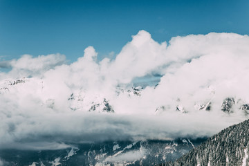 majestic snow-covered mountains and white clouds in mayrhofen, austria