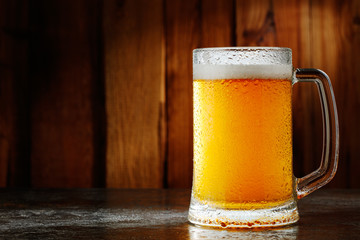 mug with beer on a wooden background