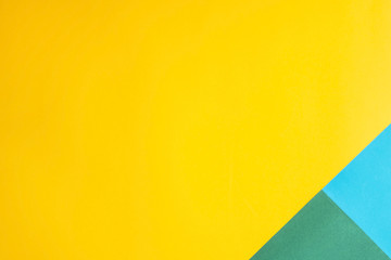 Combined multicolored decorative background. The main color is yellow and additional - green and blue. Copyspace, flat lay, top view