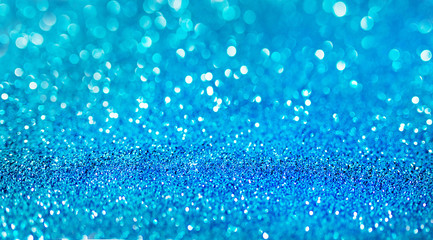 Naklejka na ściany i meble Blue defocused glitter background with copy space. Holiday texture. Wallpaper. Glitter light spots on blue background, defocused