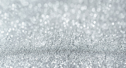 Obraz premium Sparkling festive background. Melting macro snowflakes close up with bokeh at the background. Image with small depth of field. Silver defocused glitter background with copy space.