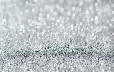 Sparkling festive background. Melting macro snowflakes close up with bokeh at the background. Image with small depth of field. Silver defocused glitter background with copy space.