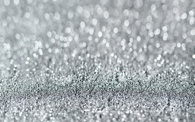 Sparkling festive background. Melting macro snowflakes close up with bokeh at the background. Image with small depth of field. Silver defocused glitter background with copy space.