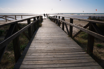 Fototapeta na wymiar wooden bridge on beach with dark clouds before storm in Tarifa, Spain