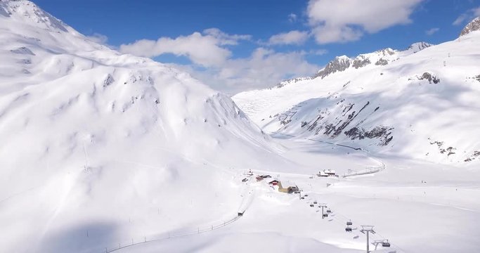 Scenic aerial shot of snow covered mountain and ski resort in the Swiss Alps
