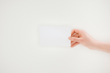 cropped shot of woman holding blank paper isolated on white