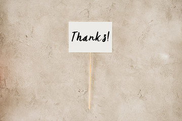top view of thanks lettering on placard on concrete surface