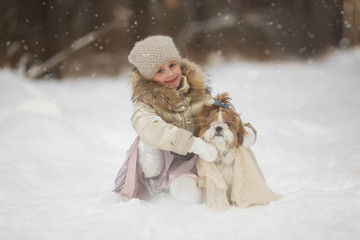 Obraz premium Lovely girl warms dog shawl in winter cold forest