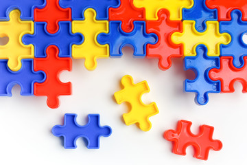 Pieces from a colorful jigsaw puzzle arranged to form a page on white background. Break barriers together for autism concept