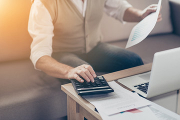 Growth investor auditor graphs bill people think insurance job entrepreneur paperwork plan stock shares person notebook concept. Close up photo of shareholder's hand using pressing buttons calculator