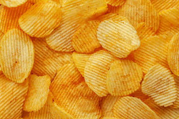 Food background of corrugated potato chips