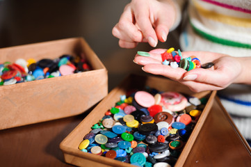 colorful sewing buttons in the hands, selection of the right buttons