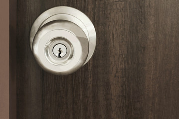 Close up metal handle on a old wooden door, modern knob security lock.