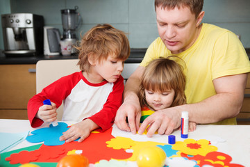 father and the children prepare together Paper decor. children's creativity.
Tools and materials for children's art creativity on table. Easter decor.