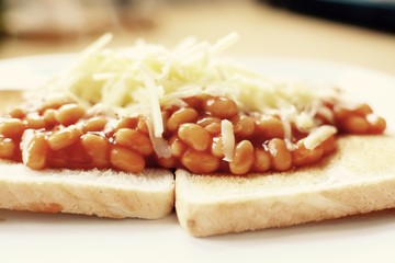 Baked beans on white toast topped with grated cheddar cheese - filter applied