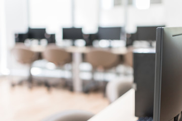 Computer lab blur background with pc desktop computer machine in blurry school class or office desk workspace