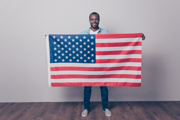 It's my native country! Full length portrait of cheerful glad joyful confident with beaming smile guy wearing denim casual outfit, holding flag of the USA in front of him, isolated on gray background - Powered by Adobe