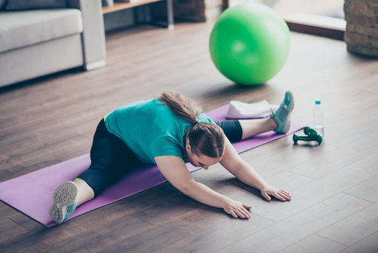 Young Woman Does A Side Split Exercise At Home