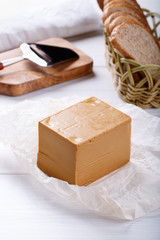 Norwegian brunost on white table. Traditional Scandinavian brown cheese.