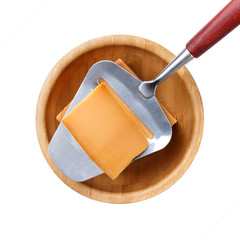 Norwegian brunost in wooden bowl Isolated on white. Traditional Scandinavian brown cheese. Top view.