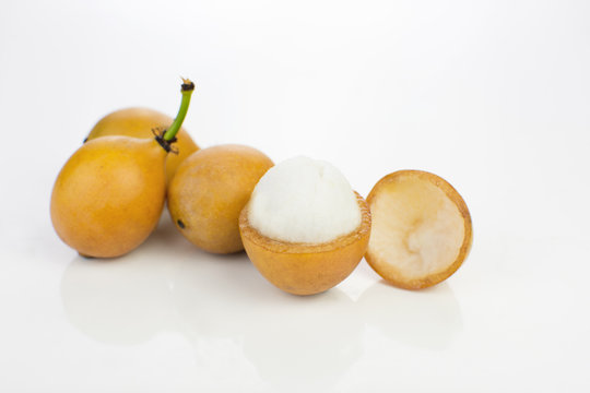 Open Bolivian exotic fruit called Achachairu in white background