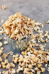 Salt popcorn or sweet popcorn on old grey background.
