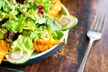 Smoke salmon dumpling salad on a white plate and on a light wooden table. Chinese food. Food chopsticks. Close-up view with copy space. 