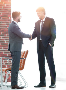 Two business people shake hands in the office