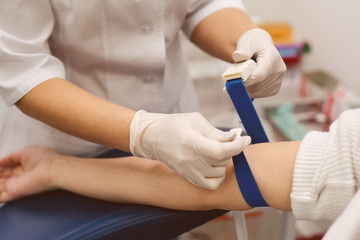 Tightening the harness on the arm before taking blood. Manipulation cabinet. Hematology. Health and...