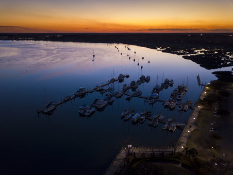 Aerial view of marina and sailboats at twilight.