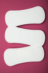 White gentle hygienic pads on a red background.